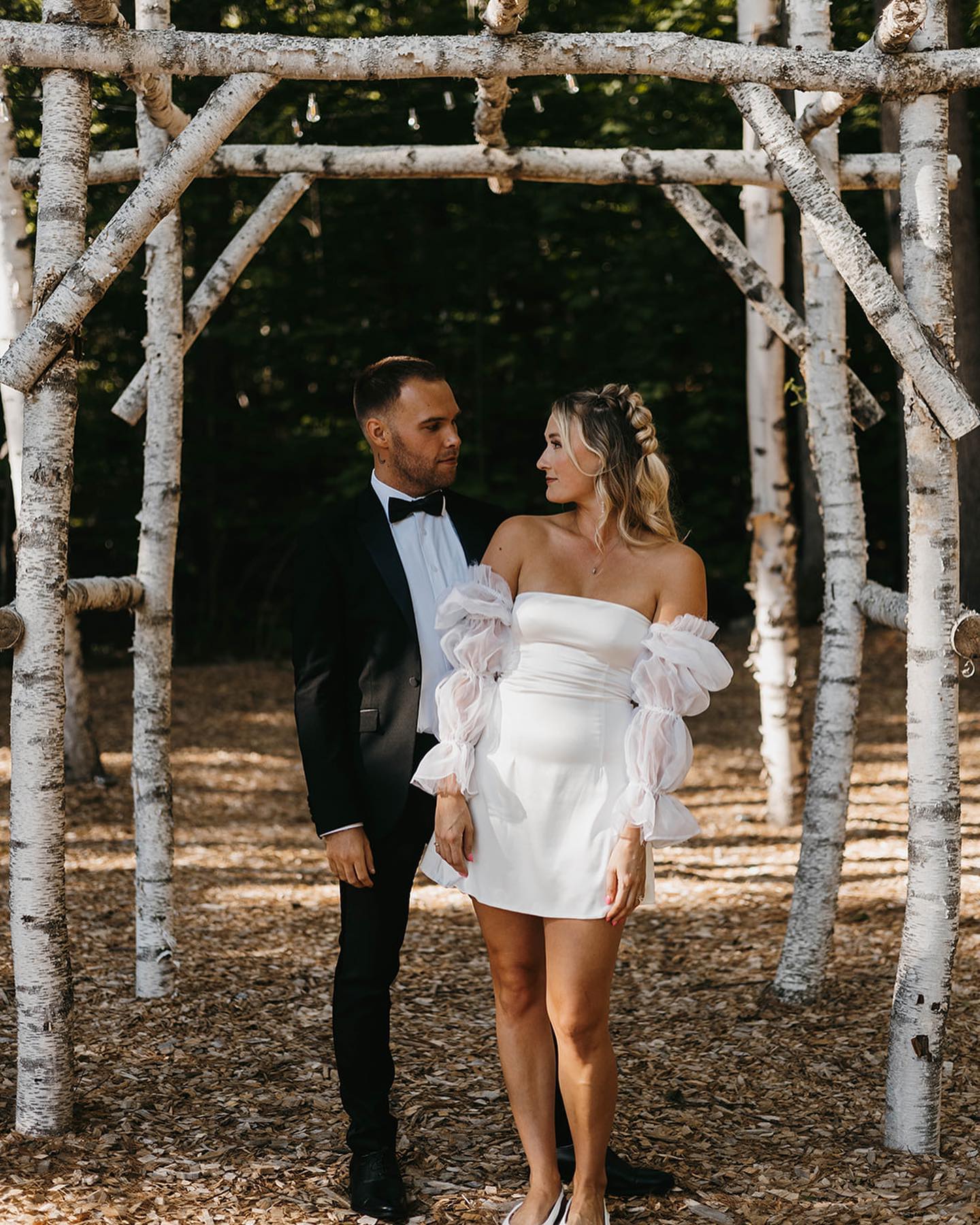 bride and groom under rustic wedding altar