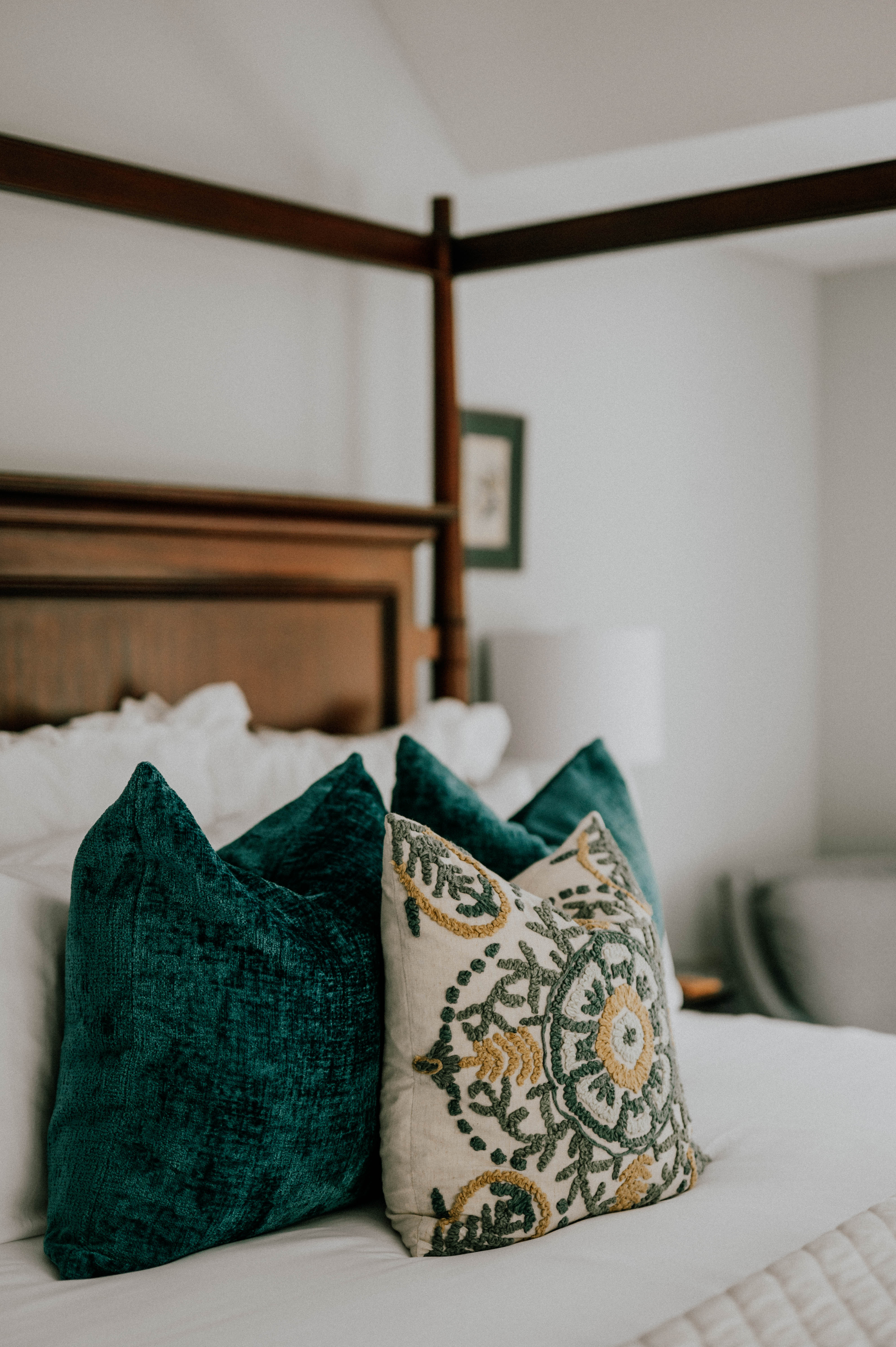 green throw pillows on four poster bed