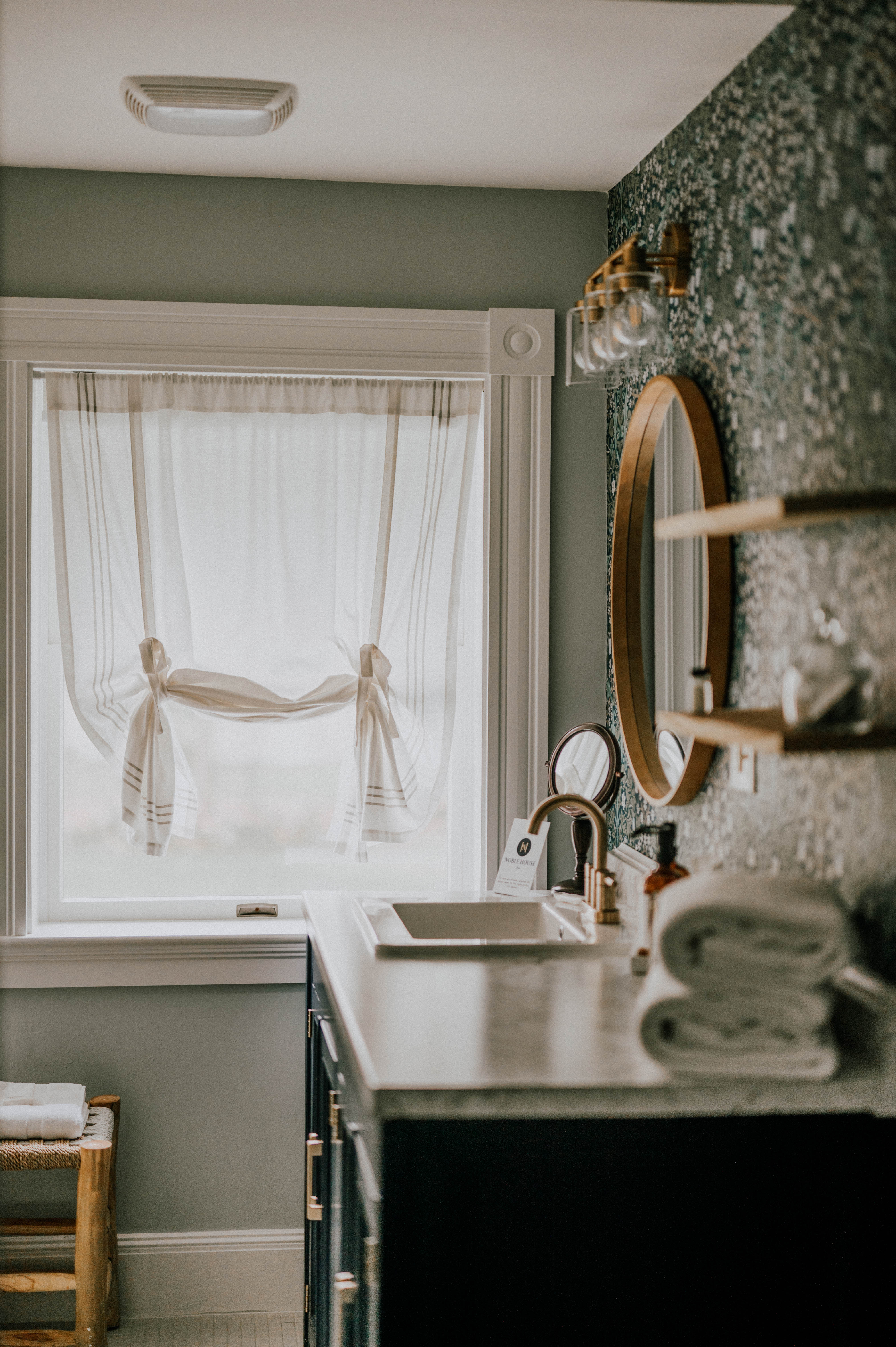 spacious bathroom with green wallpaper