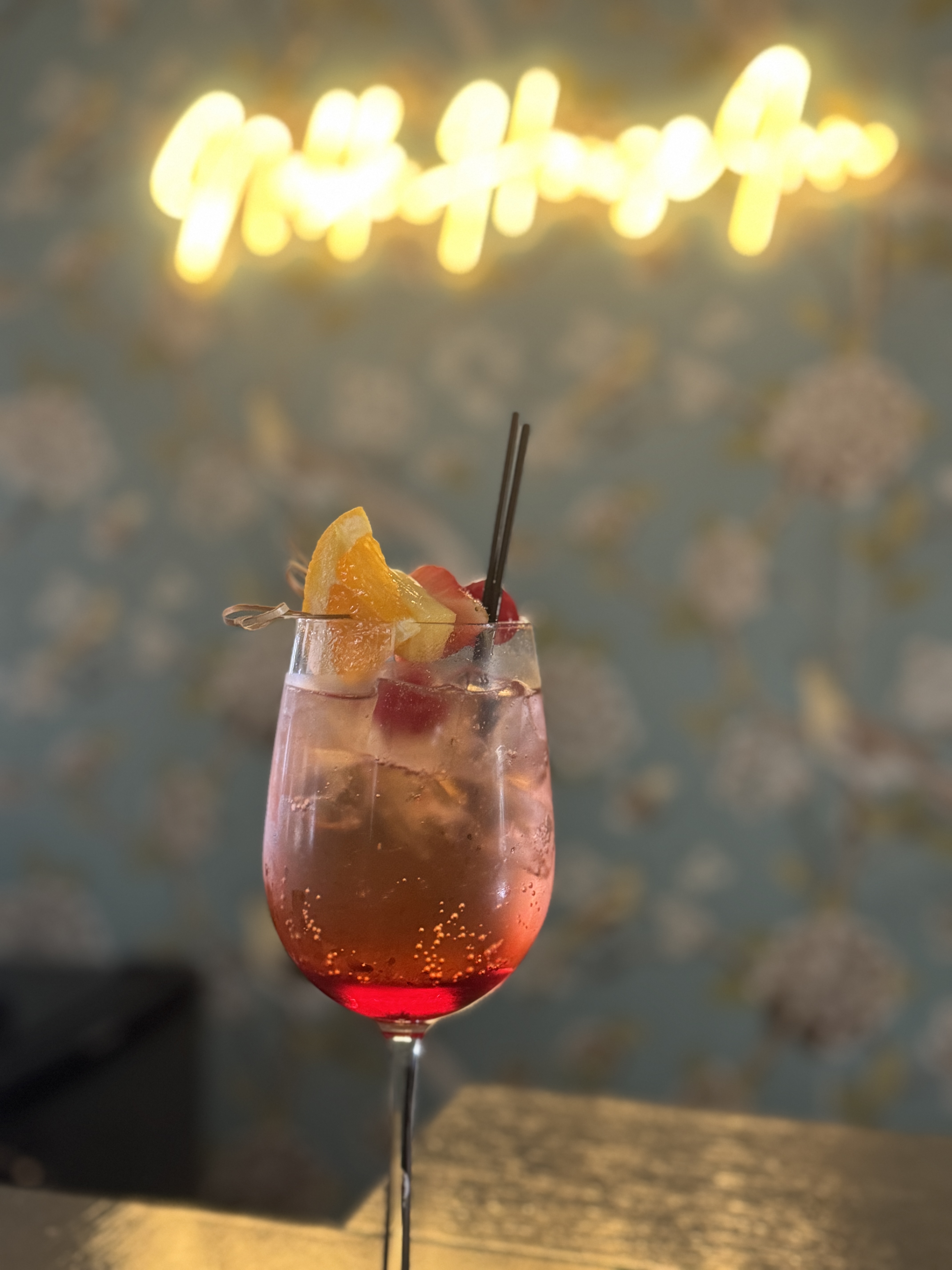 cocktail with neon sign in background