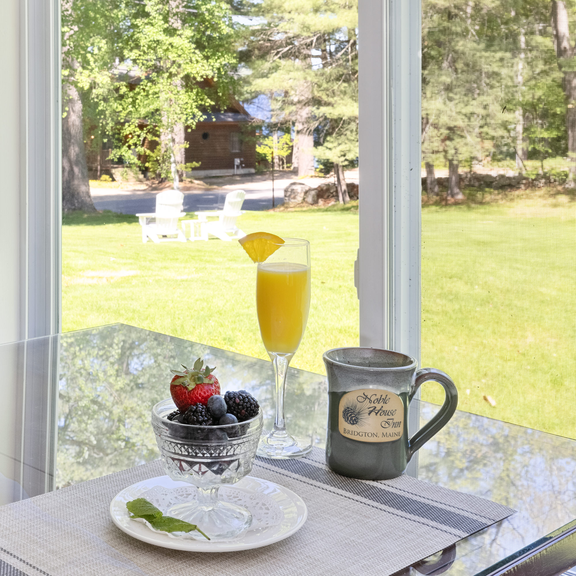 mimosa, coffee, and bowl of fruit on patio table