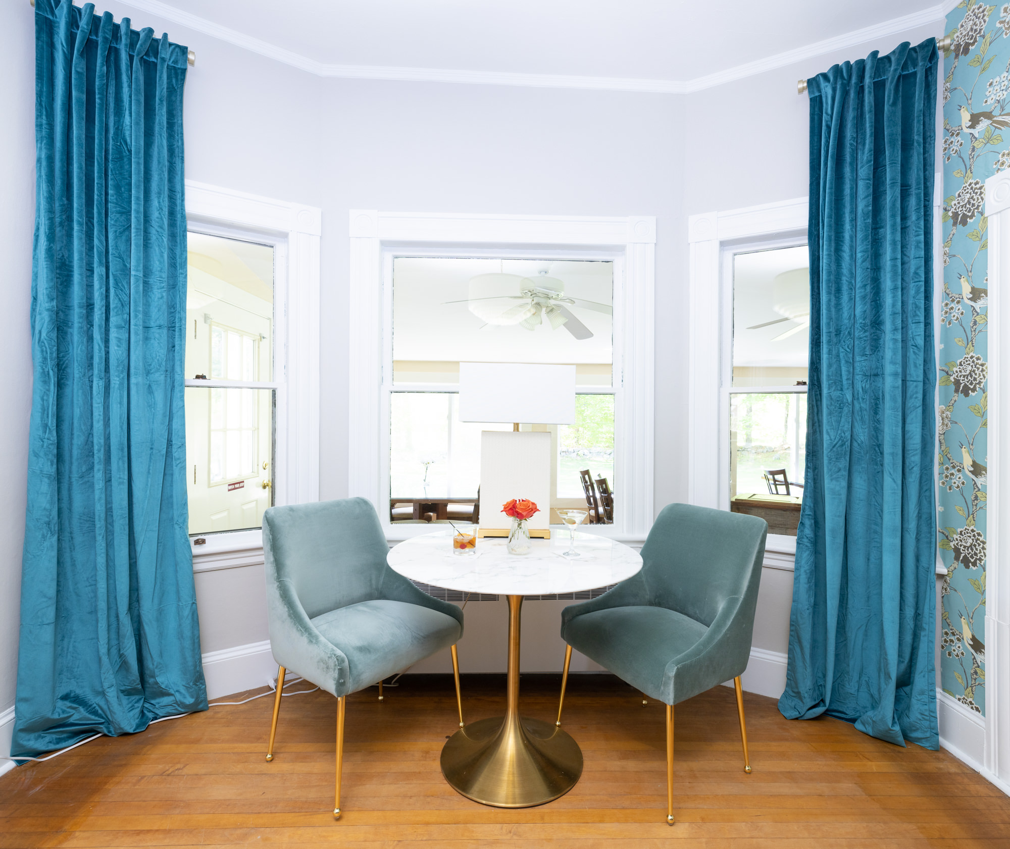 table with velvet chairs in bay window at noble house inn bar